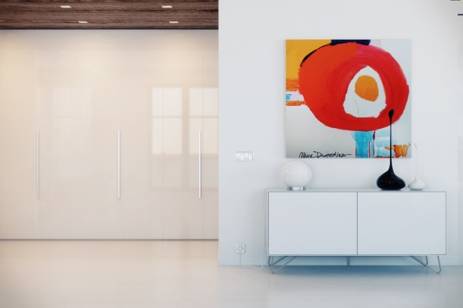 The beautiful elements of this home have been highlighted, whilst more functional pieces take a step back.  For instance, take note of how the quirky asymmetrical vases appear to drip from the modern artwork above the console, which blends with the color matched wall behind it, or how the run of huge storage cupboards are almost invisible along one wall in white gloss and slim-line chrome handles.